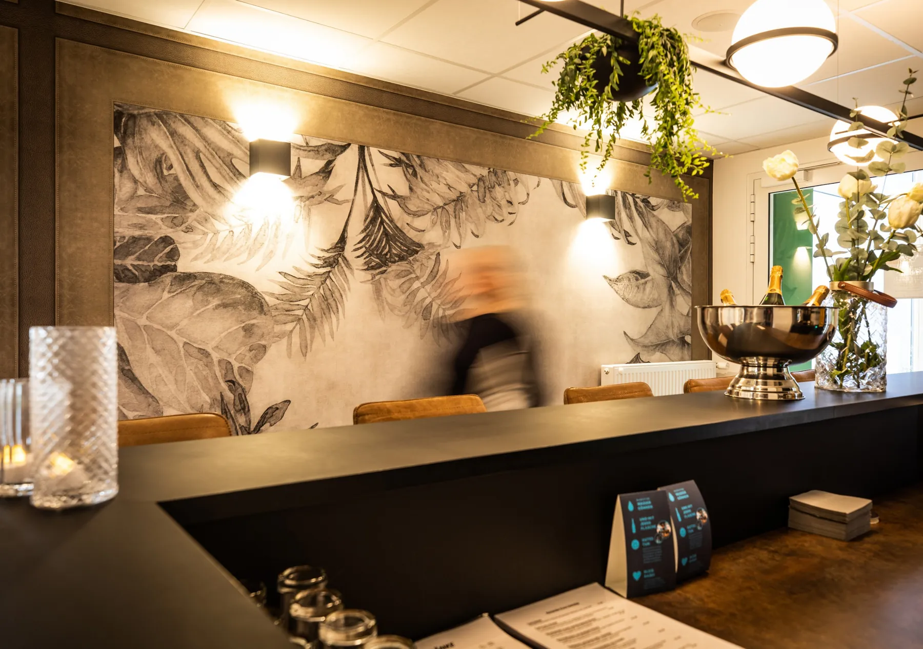Hotelbar mit dunkler Theke und Wandbild im Hotel am Zoo Neunkirchen