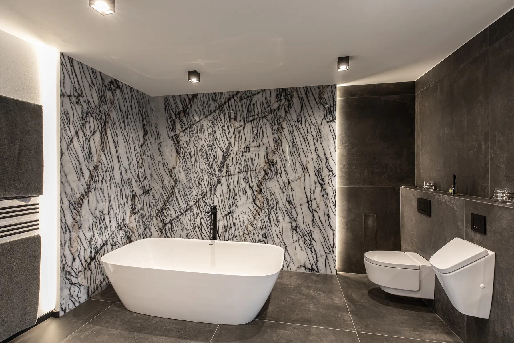 Bad mit freistehender Badewanne vor gemusterter Wand in Schwarz und Weiß im Penthouse Black & White