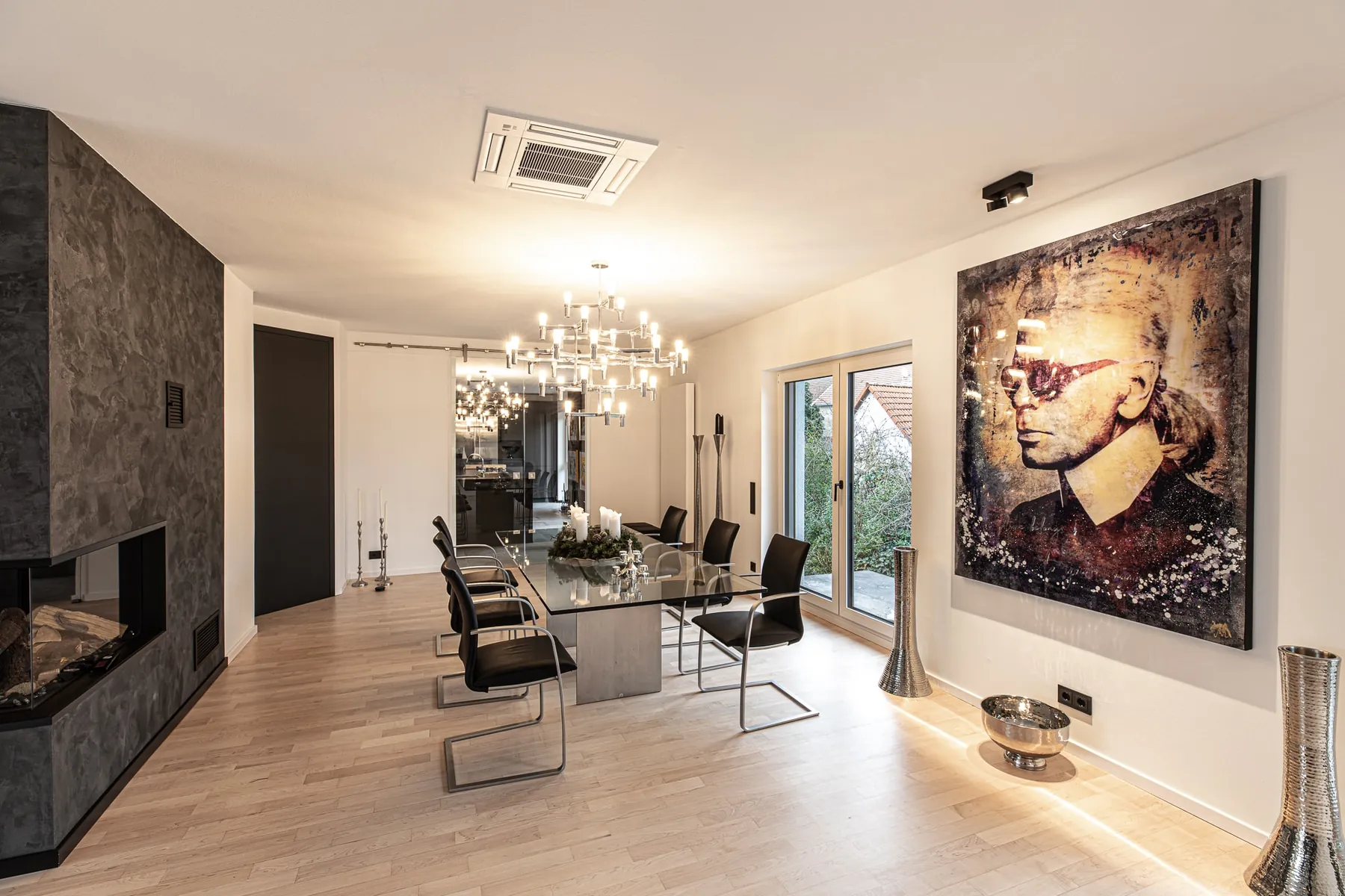 Essbereich mit Glastisch, Kronleuchter und großformatiger Kunst im Penthouse Black & White