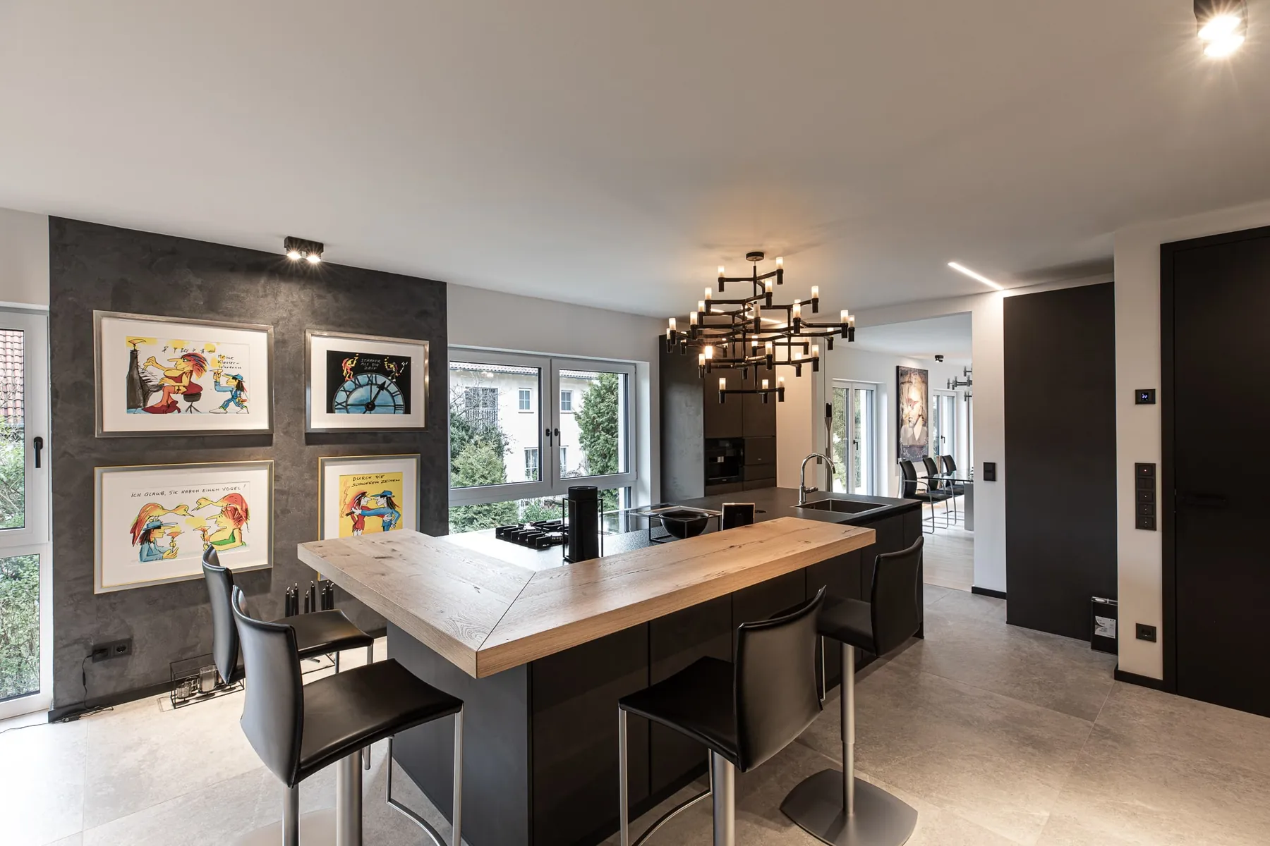 Kochinsel mit Holztheke vor einer Wand mit bunten Bildern im Penthouse Black & White