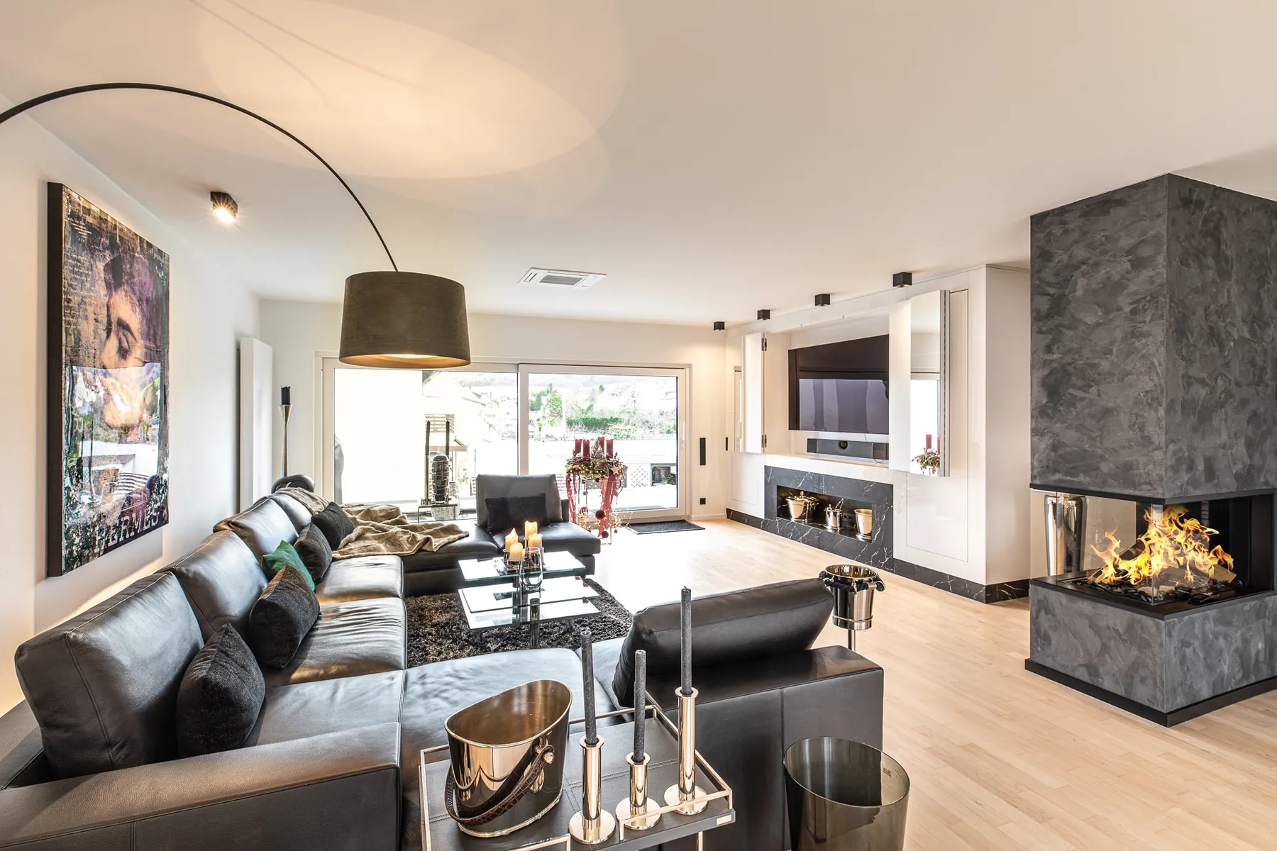 Wohnbereich mit Ledersofa und Kamin im Penthouse Black & White